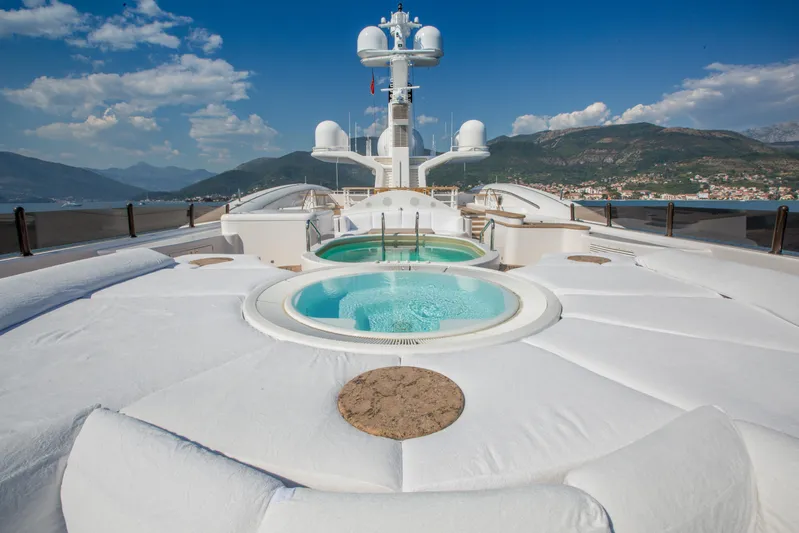 Pelorus Yacht Photos Pics Luxurious 2003 Lurssen Custom yacht deck with jacuzzi, overlooking scenic mountains and coastline.