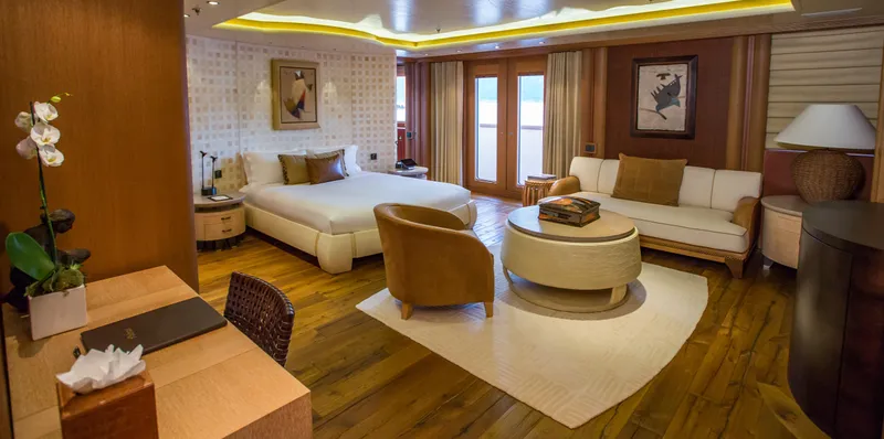 Pelorus Yacht Photos Pics Luxurious yacht interior with elegant furnishings, featuring a bed, sofa, and wooden decor. Lurssen Custom 2003.