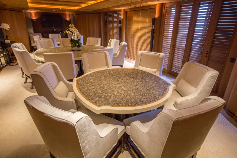 Pelorus Yacht Photos Pics Luxurious dining area on 2003 Lurssen Custom yacht with elegant seating and wooden accents.