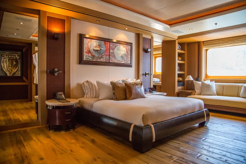Pelorus Yacht Photos Pics Luxurious yacht bedroom with elegant decor, wooden flooring, and large windows, Lurssen Custom 2003.