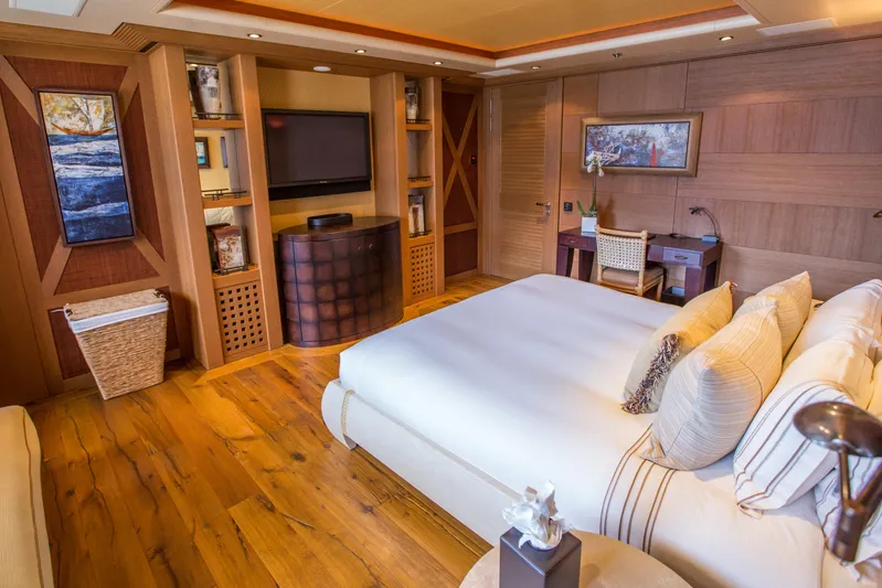 Pelorus Yacht Photos Pics Luxurious yacht bedroom with wooden decor, plush bedding, and modern amenities, Lurssen Custom 2003.