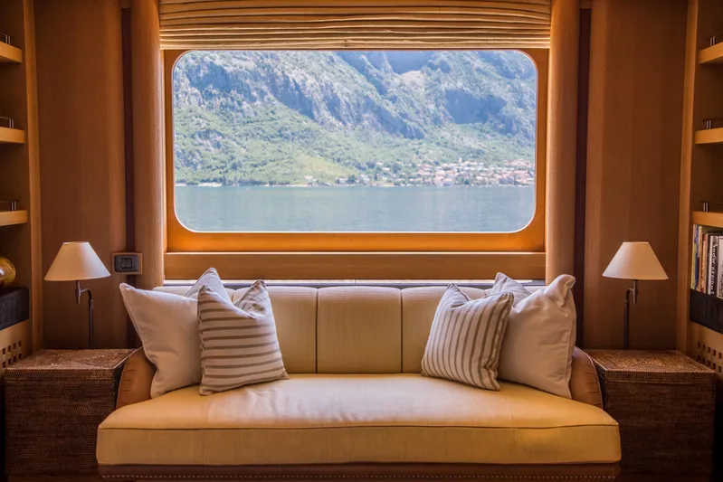 Pelorus Yacht Photos Pics Luxurious yacht interior with a cozy sofa, large window view of mountains and water. Lurssen Custom 2003.