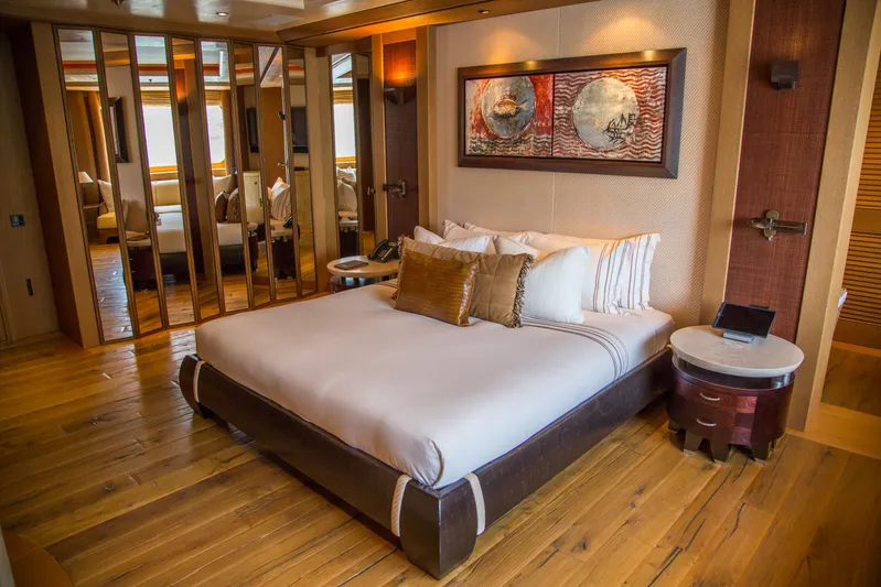 Pelorus Yacht Photos Pics Luxurious bedroom interior on a 2003 Lurssen Custom yacht, featuring elegant decor and wooden flooring.