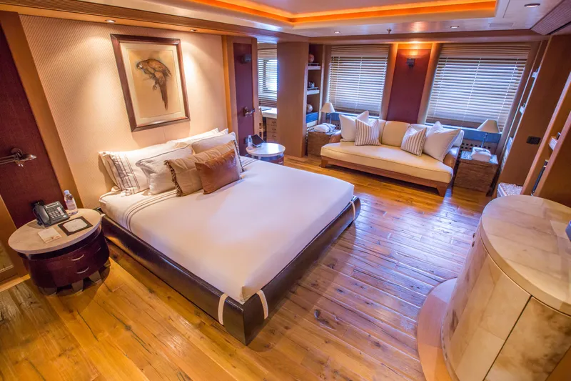 Pelorus Yacht Photos Pics Luxurious Lurssen Custom yacht bedroom, 2003 model, featuring elegant wood flooring and cozy decor.