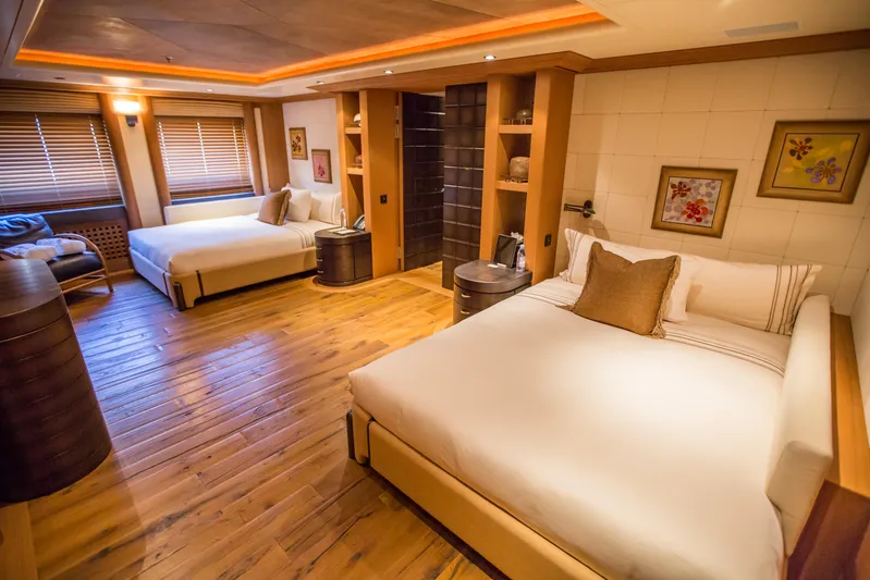 Pelorus Yacht Photos Pics Luxurious Lurssen Custom 2003 yacht bedroom with wooden floors and elegant decor.