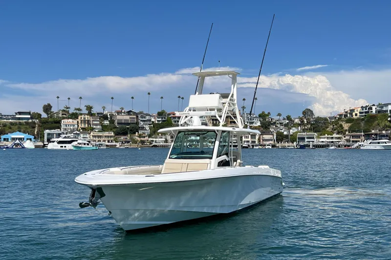 M22 Yacht Photos Pics 2019 Boston Whaler 380 Outrage boat on water, coastal homes in background.
