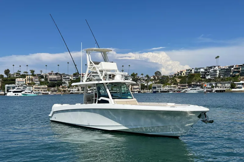 M22 Yacht Photos Pics 2019 Boston Whaler 380 Outrage boat on calm water with coastal homes in the background.