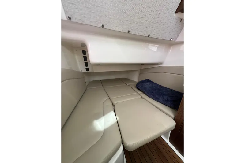 M22 Yacht Photos Pics 2019 Boston Whaler 380 Outrage cabin interior with beige seating and blue cushion.