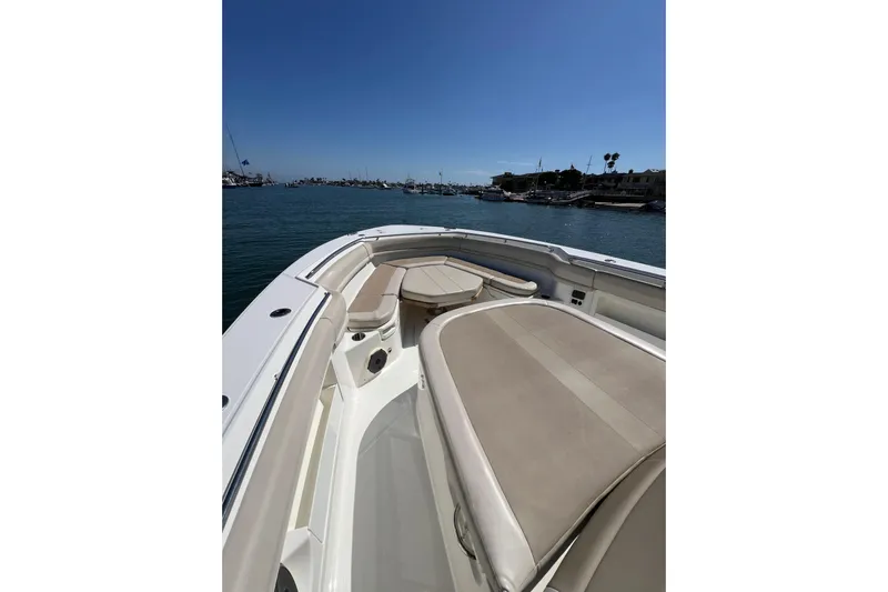 M22 Yacht Photos Pics 2019 Boston Whaler 380 Outrage boat interior with cushioned seating, docked in a marina.