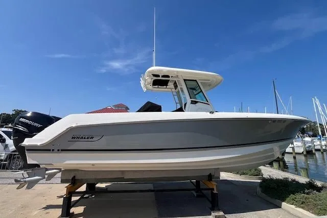  Yacht Photos Pics 2020 Boston Whaler 280 Outrage boat docked at a marina under clear blue skies.