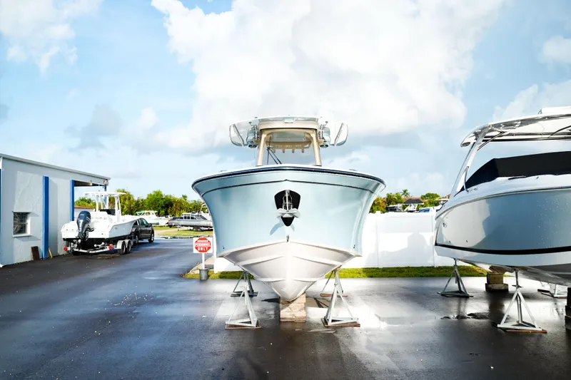  Yacht Photos Pics 2021 Grady-White Canyon 271 boat on display at a marina under a cloudy sky.