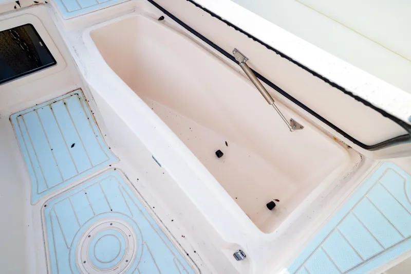  Yacht Photos Pics 2021 Grady-White Canyon 271 boat storage compartment with blue non-slip flooring.