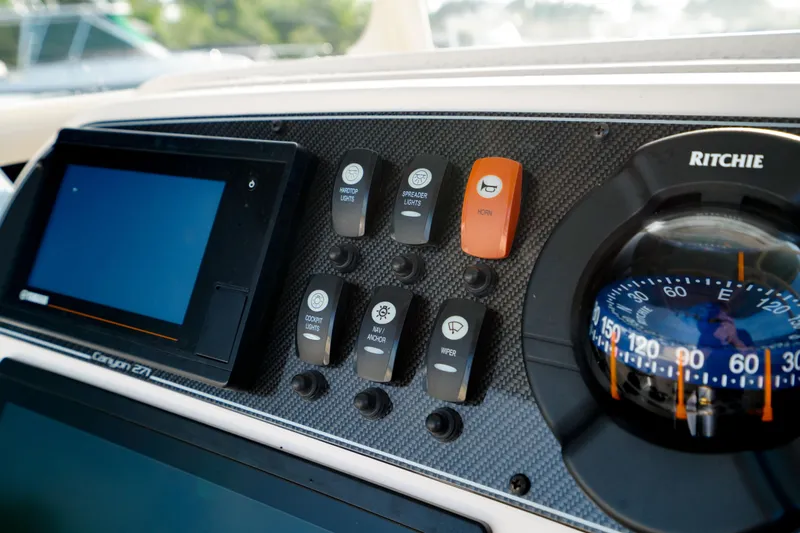  Yacht Photos Pics Control panel of 2021 Grady-White Canyon 271 boat with compass and navigation controls.