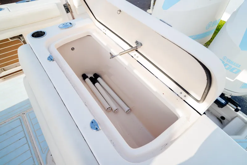  Yacht Photos Pics 2021 Grady-White Canyon 271 boat storage compartment with open lid and rods inside.