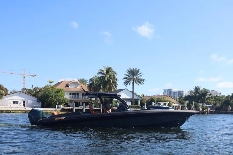 New 2025 Skipper 38 Twin 400 V10 Yacht Photos Pics 2025 Skipper-BSK 38 boat cruising on a sunny waterfront with palm trees and houses.