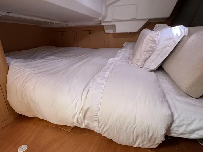 Gayle Force Yacht Photos Pics Cozy cabin bed in a 2014 Beneteau Oceanis 38 sailboat, featuring white bedding and wooden interior.