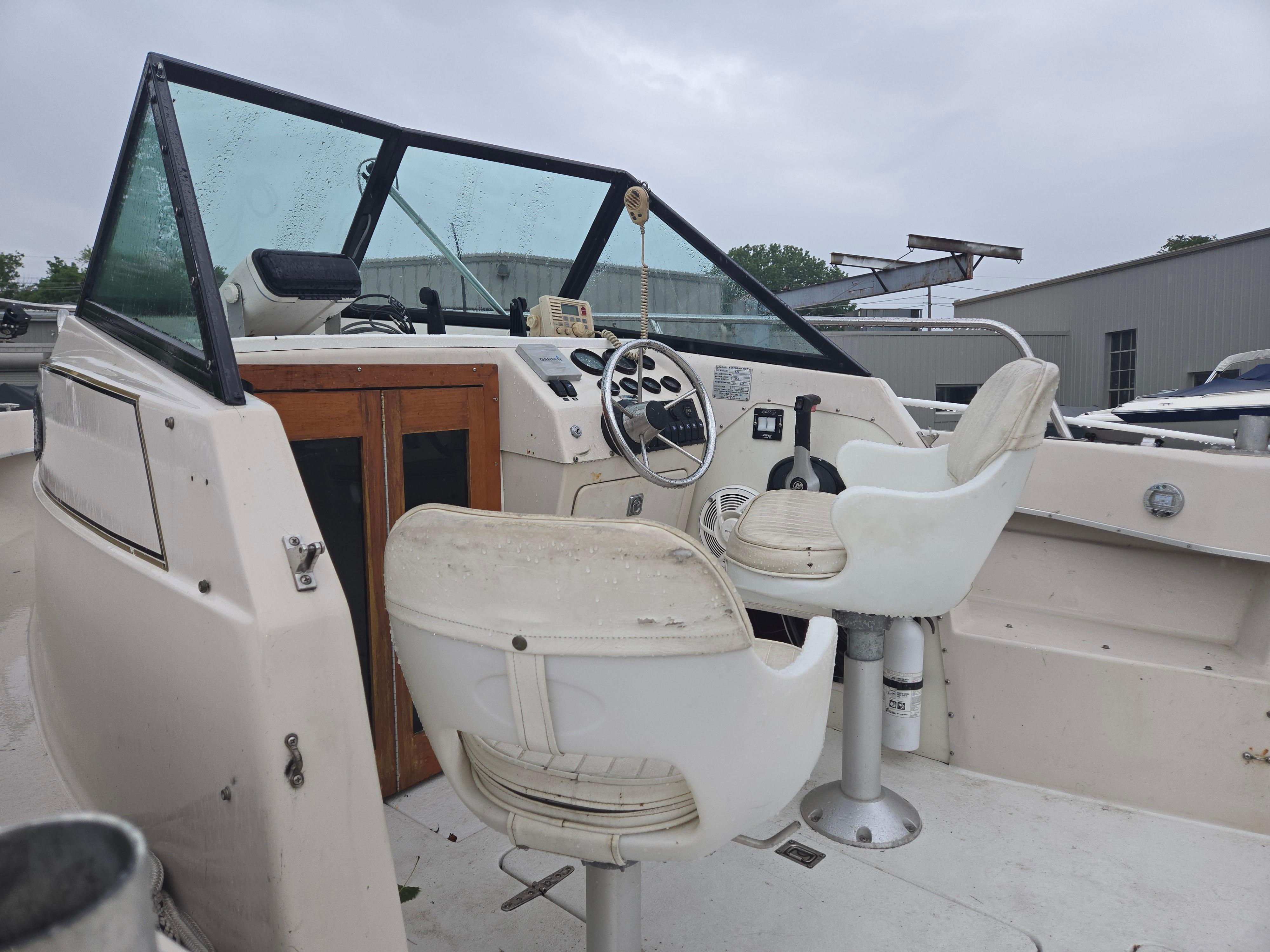 1992 Dixie 21 boat interior with steering wheel and white seats.