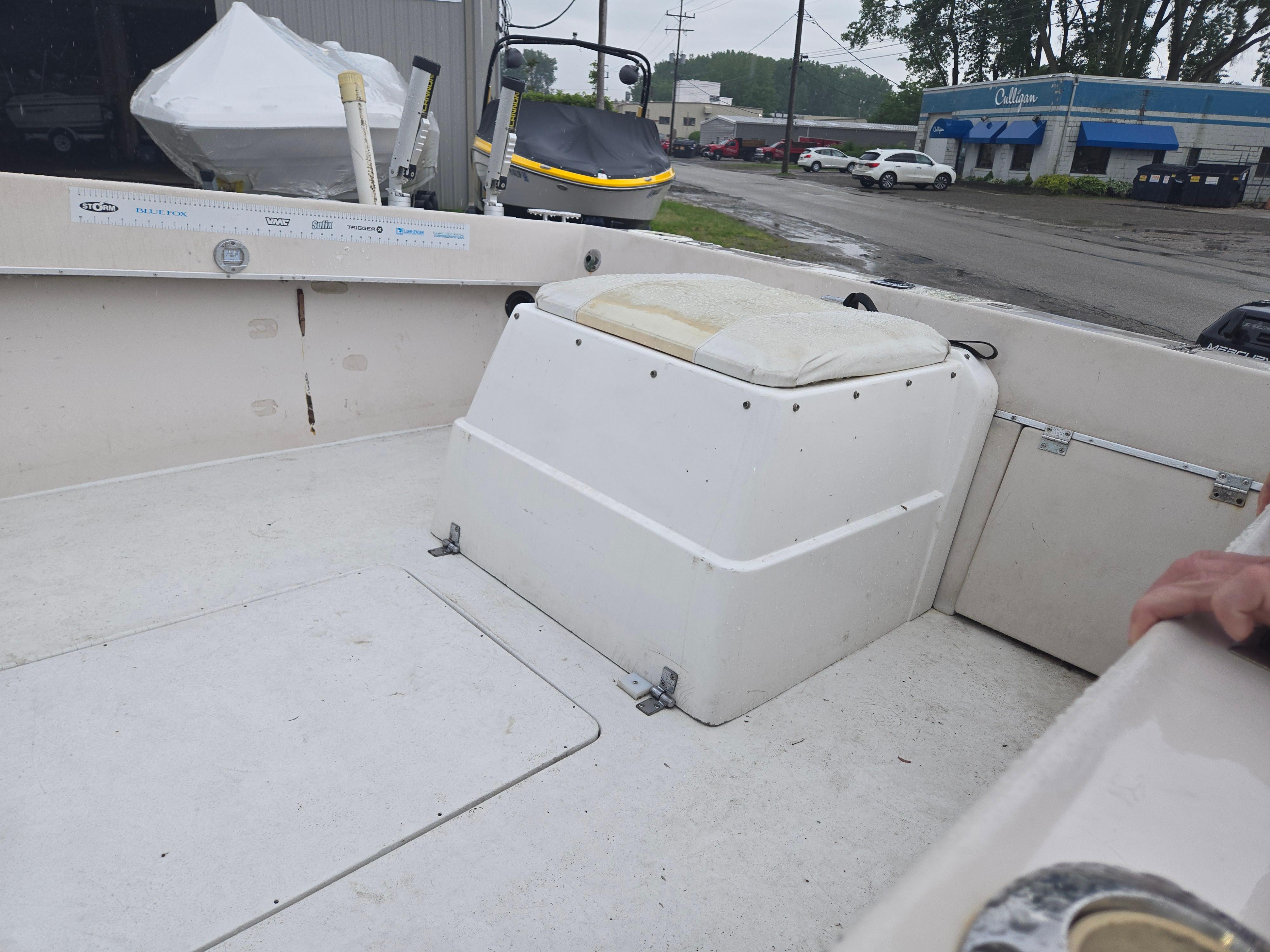 1992 Dixie 21 boat interior with seating and storage, parked near a dealership.