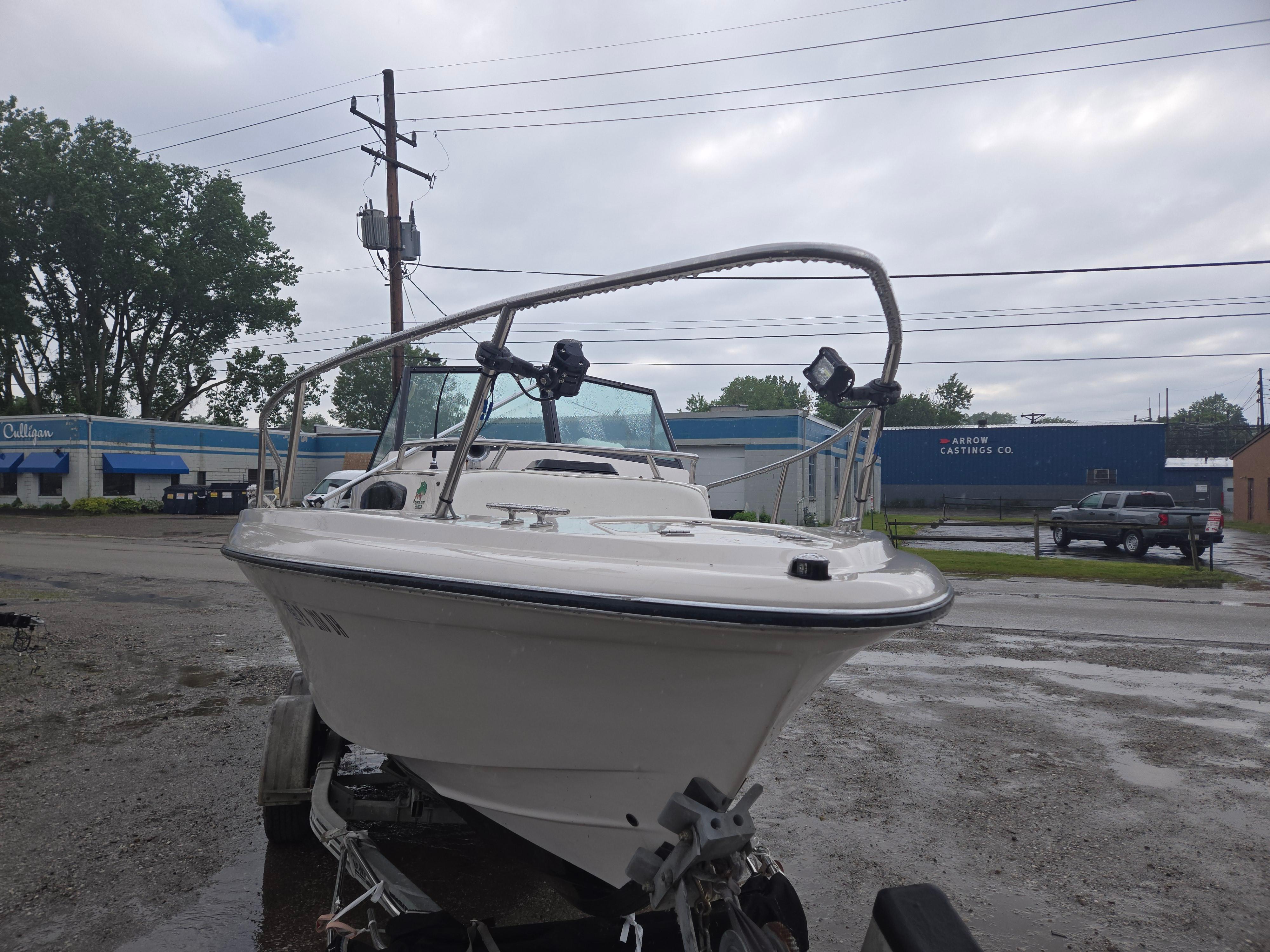 1992 Dixie 21 boat on trailer in a parking lot, overcast sky.