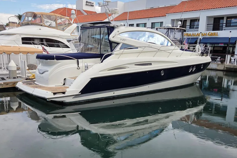 Nina & Alexander Yacht Photos Pics 2007 Cranchi Mediterranee 47 HT yacht docked in marina, reflecting on calm water.