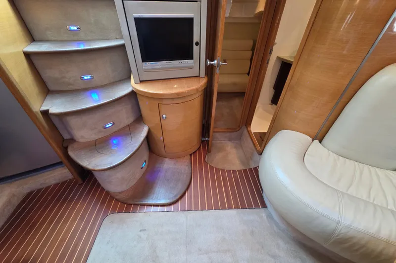 Nina & Alexander Yacht Photos Pics Interior of 2007 Cranchi Mediterranee 47 HT yacht with stairs, TV, and seating area.