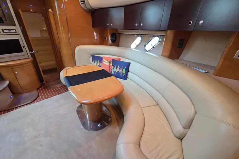 Nina & Alexander Yacht Photos Pics Luxurious interior of 2007 Cranchi Mediterranee 47 HT yacht with curved seating and wooden table.