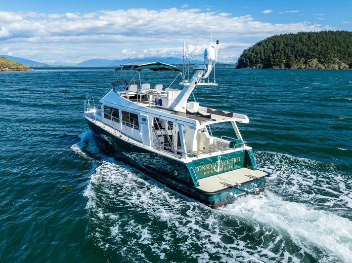 Consequence Free Yacht Photos Pics 2009 Coastal Craft 400 IPS yacht cruising on open water with scenic island backdrop.