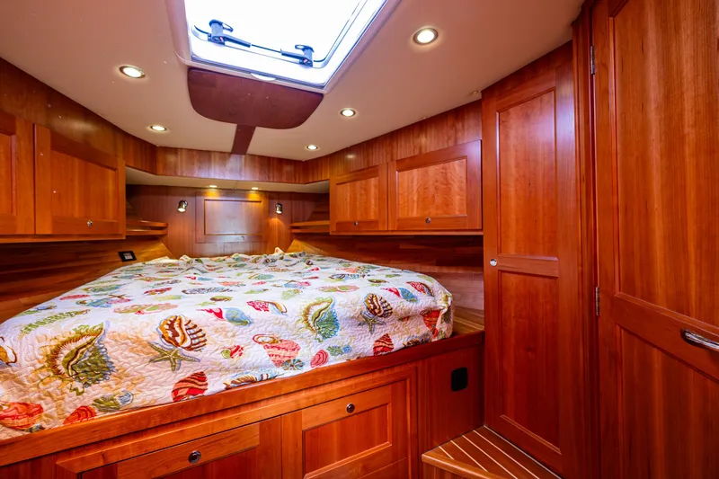 Consequence Free Yacht Photos Pics Luxurious 2009 Coastal Craft 400 IPS cabin with wood paneling and nautical-themed bedding.