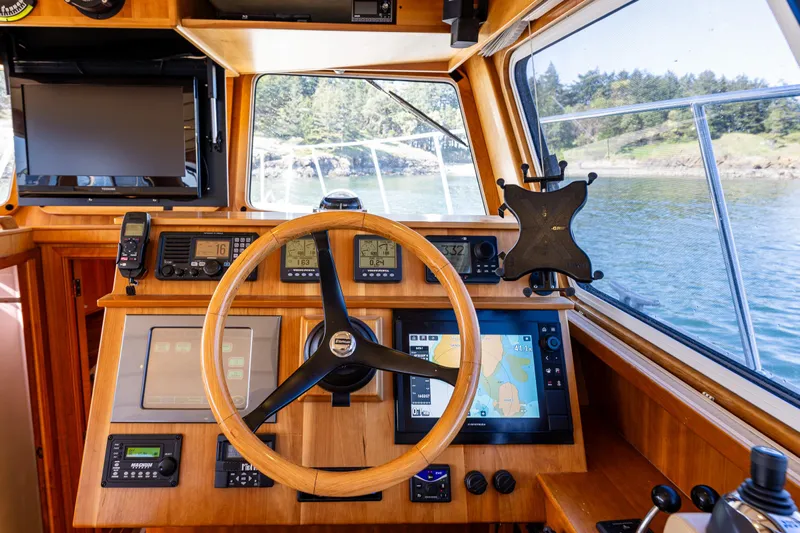 Consequence Free Yacht Photos Pics Helm of 2009 Coastal Craft 400 IPS yacht with navigation equipment and wooden steering wheel.