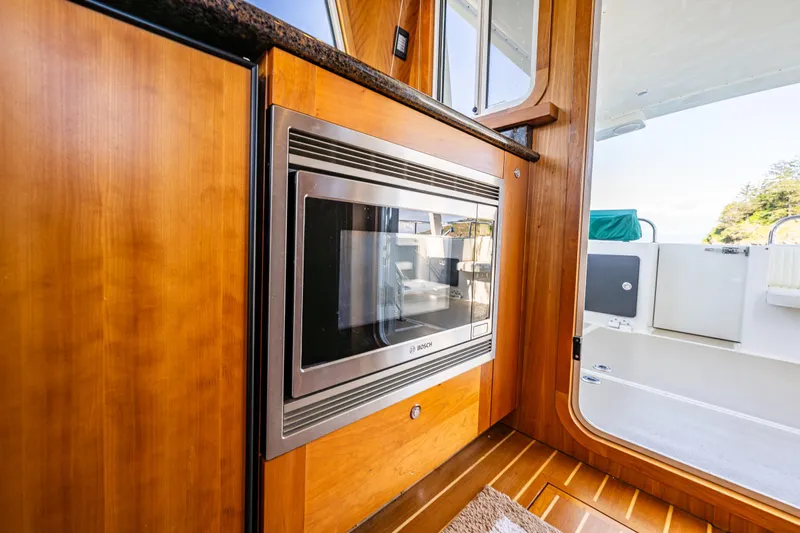 Consequence Free Yacht Photos Pics Interior of 2009 Coastal Craft 400 IPS yacht with built-in microwave and wooden cabinetry.