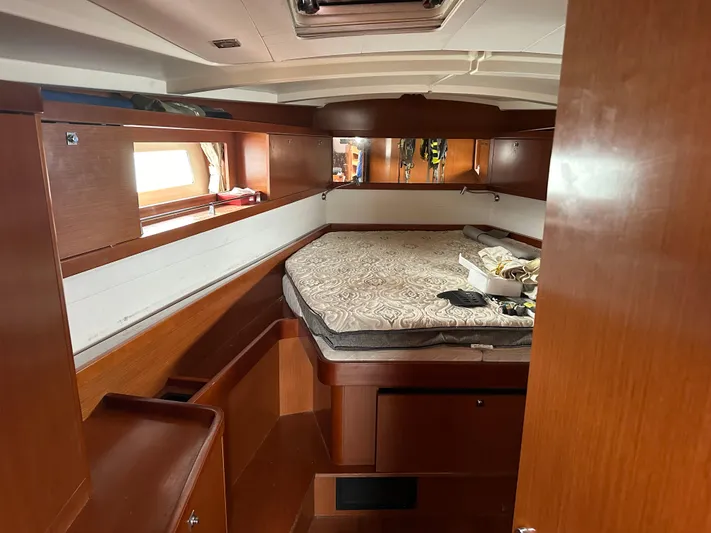 Traveller Two Yacht Photos Pics Cabin interior of 2012 Beneteau Oceanis 45 sailboat with wooden furnishings and bed.