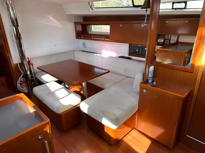 Traveller Two Yacht Photos Pics Interior of 2012 Beneteau Oceanis 45 yacht with wooden dining area and cushioned seating.
