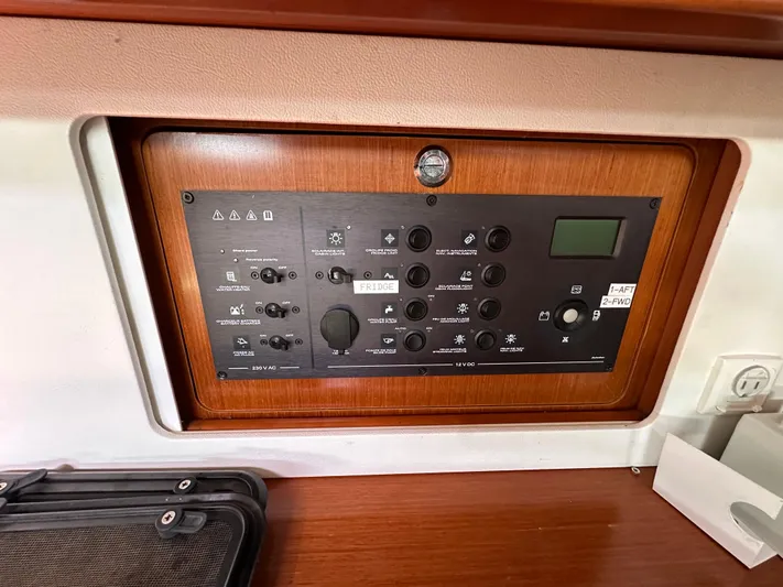 Traveller Two Yacht Photos Pics Control panel of a 2012 Beneteau Oceanis 45 sailboat, featuring various switches and a digital display.