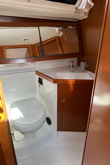 Traveller Two Yacht Photos Pics Bathroom interior of 2012 Beneteau Oceanis 45 yacht with wooden cabinetry and modern fixtures.