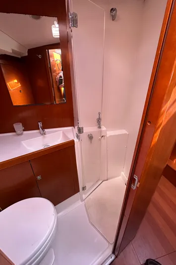 Traveller Two Yacht Photos Pics 2012 Beneteau Oceanis 45 bathroom with shower, sink, and wooden cabinetry.