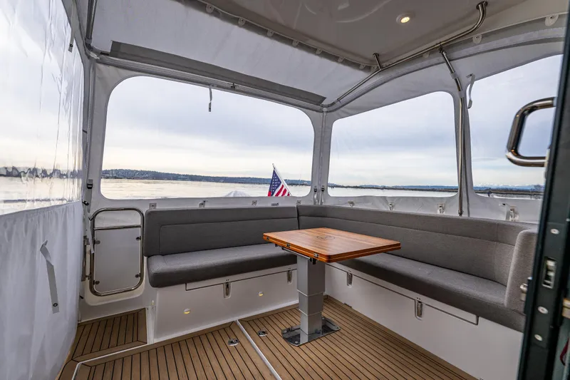 Crazy Love Yacht Photos Pics Interior of 2023 Nimbus 405 Coup&eacute; yacht with seating and table, overlooking water.