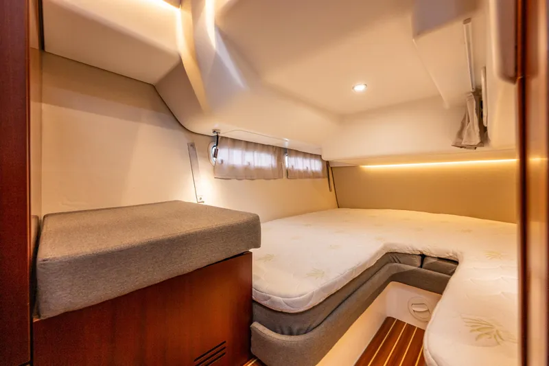 Crazy Love Yacht Photos Pics Luxurious cabin interior of 2023 Nimbus 405 Coup&eacute; with cozy bedding and ambient lighting.