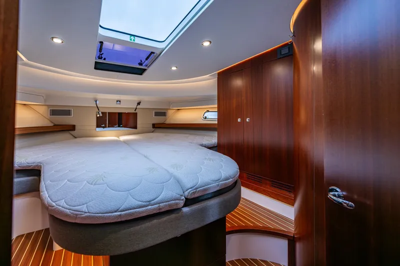 Crazy Love Yacht Photos Pics Luxurious interior of 2023 Nimbus 405 Coup&eacute; yacht with spacious bed and wooden cabinetry.