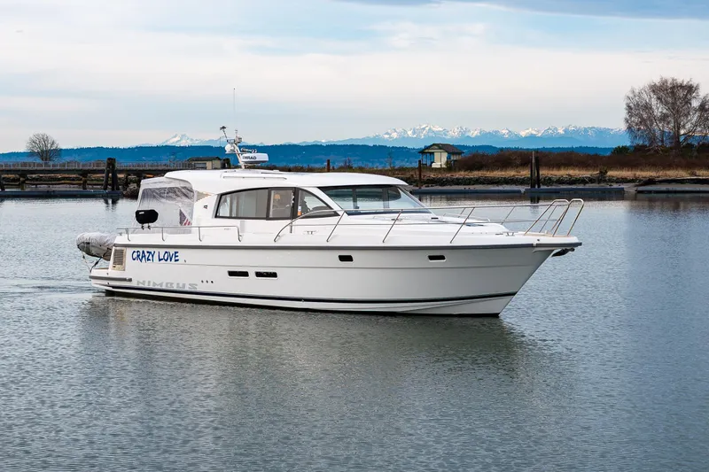 Crazy Love Yacht Photos Pics 2023 Nimbus 405 Coup&eacute; yacht on calm water with scenic mountain backdrop.