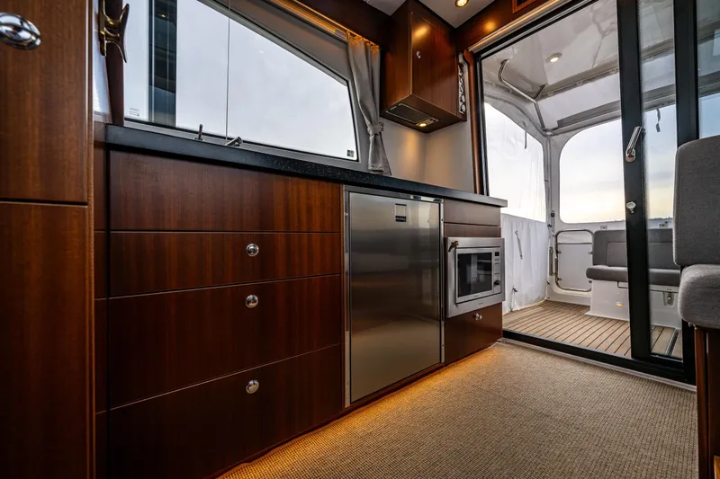 Crazy Love Yacht Photos Pics Luxurious interior of 2023 Nimbus 405 Coup&eacute; yacht with modern kitchen and elegant wood finish.