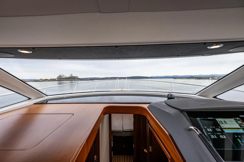 Crazy Love Yacht Photos Pics Interior view from the helm of a 2023 Nimbus 405 Coup&eacute; yacht, overlooking calm waters.
