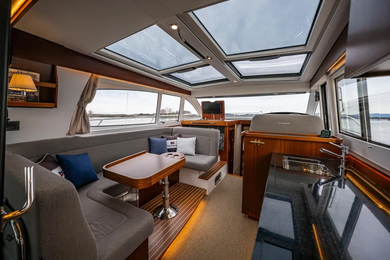 Crazy Love Yacht Photos Pics Luxurious interior of 2023 Nimbus 405 Coup&eacute; yacht with panoramic windows and elegant furnishings.