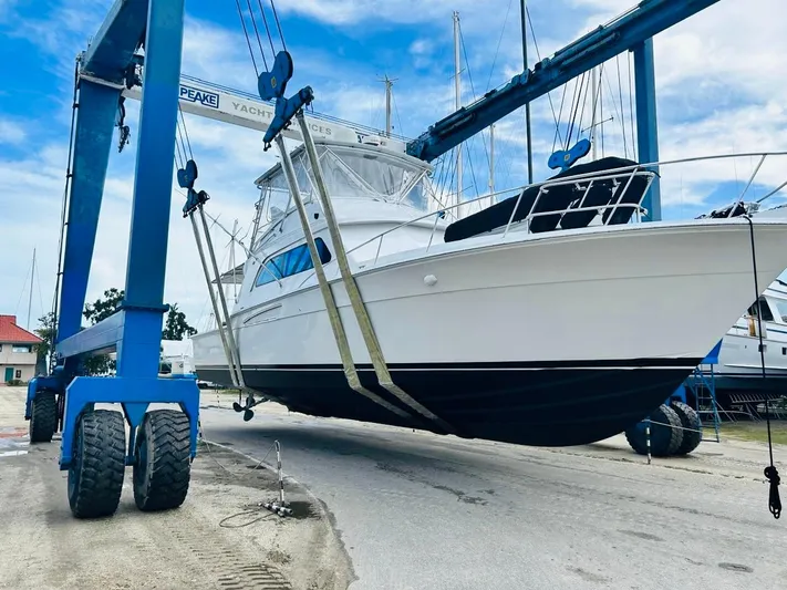  Yacht Photos Pics 1988 Bertram 54' yacht being lifted by a boat hoist at a marina.