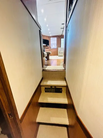  Yacht Photos Pics Interior view of 1988 Bertram 54' yacht, featuring carpeted stairs and wood-paneled walls.