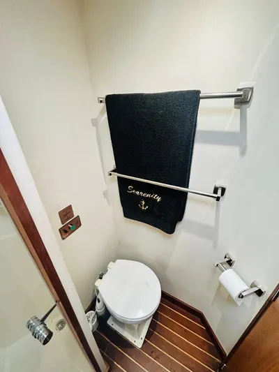  Yacht Photos Pics 1988 Bertram 54' yacht bathroom with towel, toilet, and wooden floor.