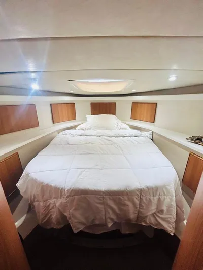  Yacht Photos Pics Cozy bedroom interior of 1988 Bertram 54' yacht with white bedding and wooden accents.