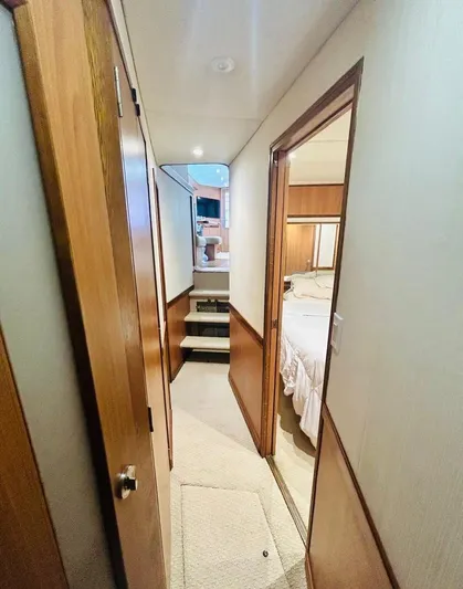  Yacht Photos Pics 1988 Bertram 54' yacht interior hallway with wood paneling and bedroom view.