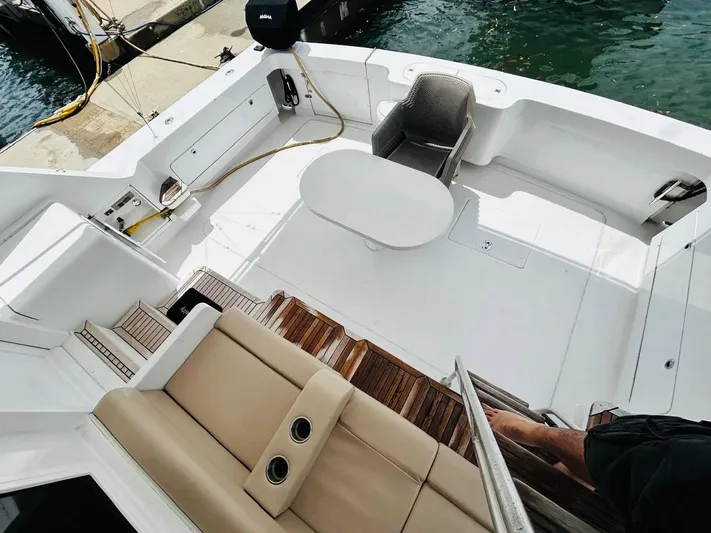  Yacht Photos Pics 1988 Bertram 54' yacht deck with seating and table, docked at marina.