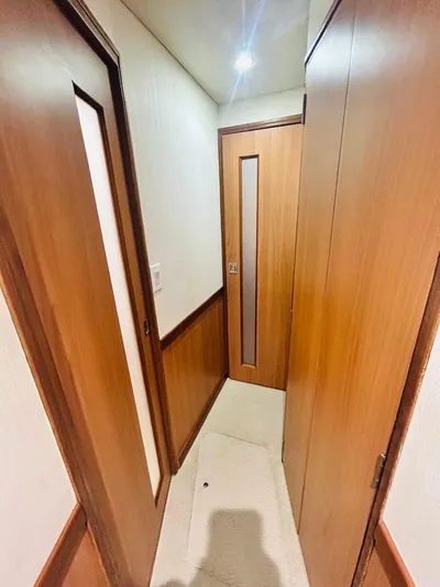  Yacht Photos Pics Interior hallway of 1988 Bertram 54' yacht with wooden doors and soft lighting.