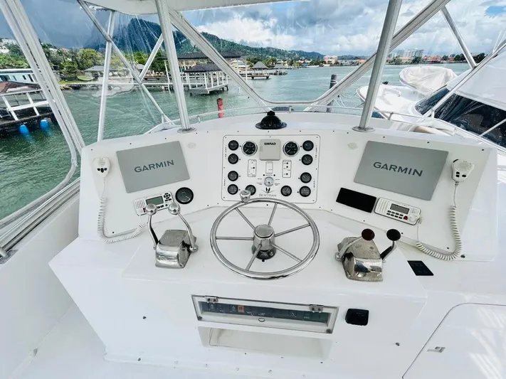  Yacht Photos Pics 1988 Bertram 54' yacht helm with Garmin navigation, dual controls, and scenic marina view.